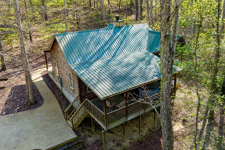 An aerial view of a cabin in the woods.