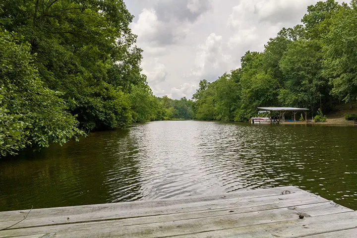A dock on a body of water with trees in the background.