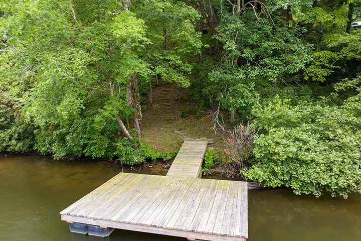 An aerial view of a dock in the middle of a wooded area.