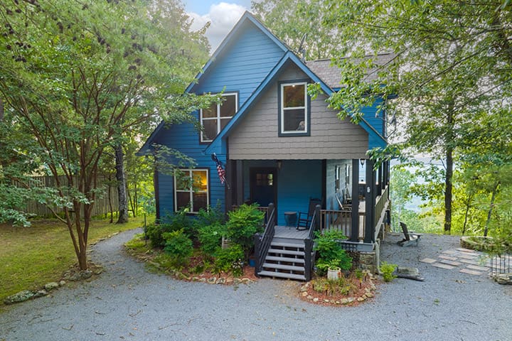 A blue house in a wooded area.