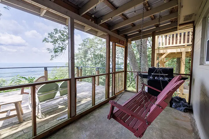 A screened in porch with a view of the mountains.
