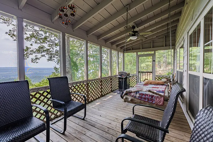 A screened in porch with a view of the mountains.