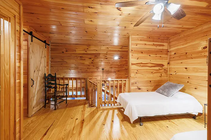 A cabin with two beds and a ceiling fan.