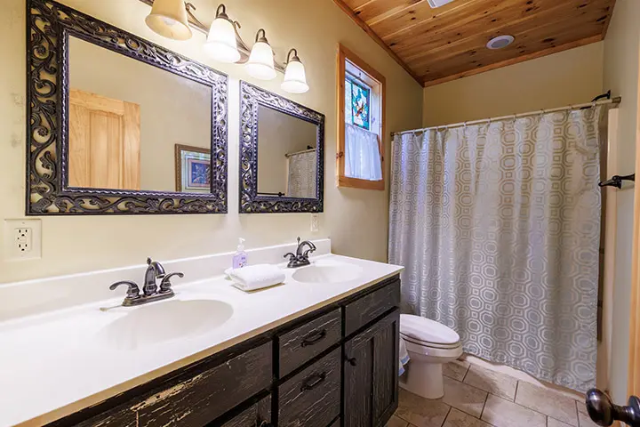 A bathroom with two sinks and a shower.