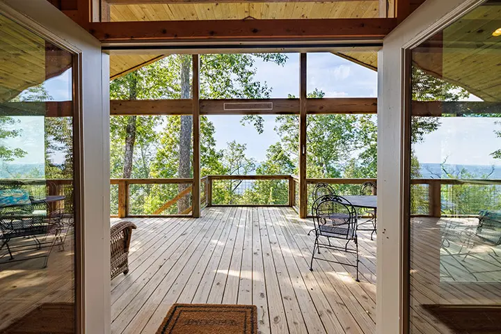 A large deck with a view of the woods.