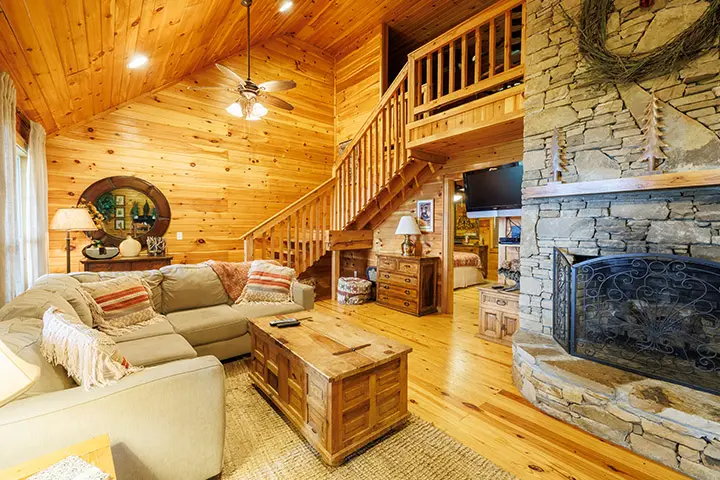 A living room in a log cabin with a fireplace.