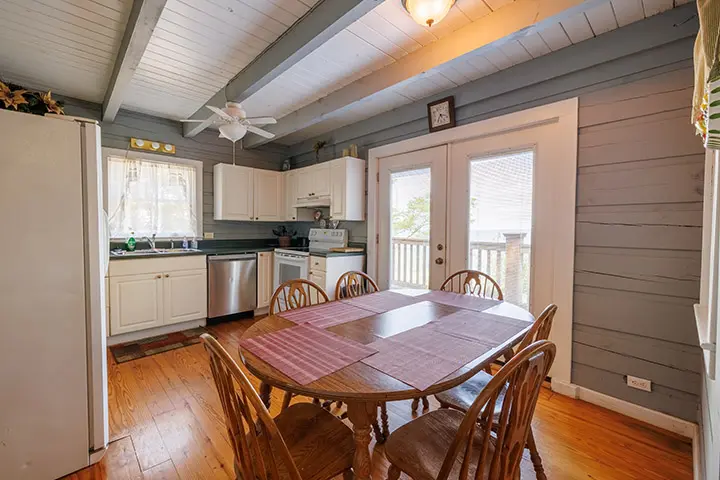A kitchen with wood floors and a table and chairs.