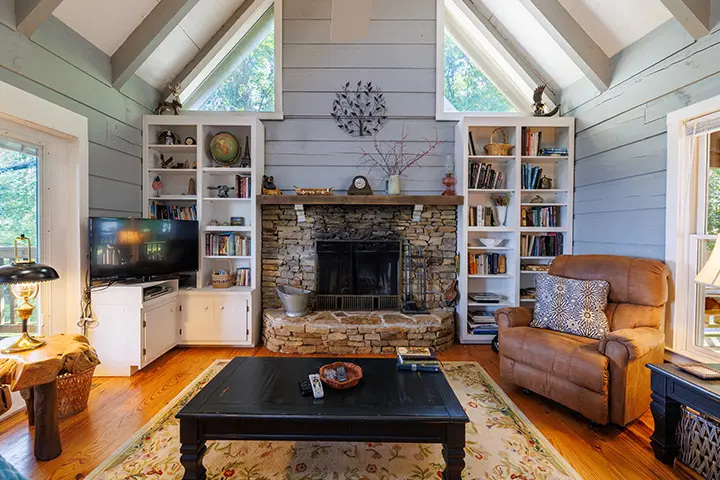 A living room with a fireplace and bookshelves.