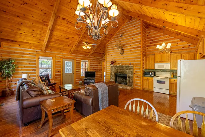 A living room and dining room in a log cabin.