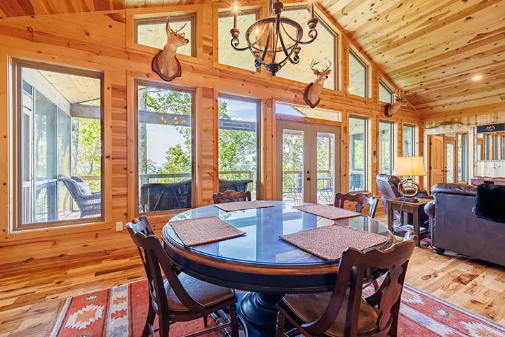 A log cabin with a dining table and chairs.