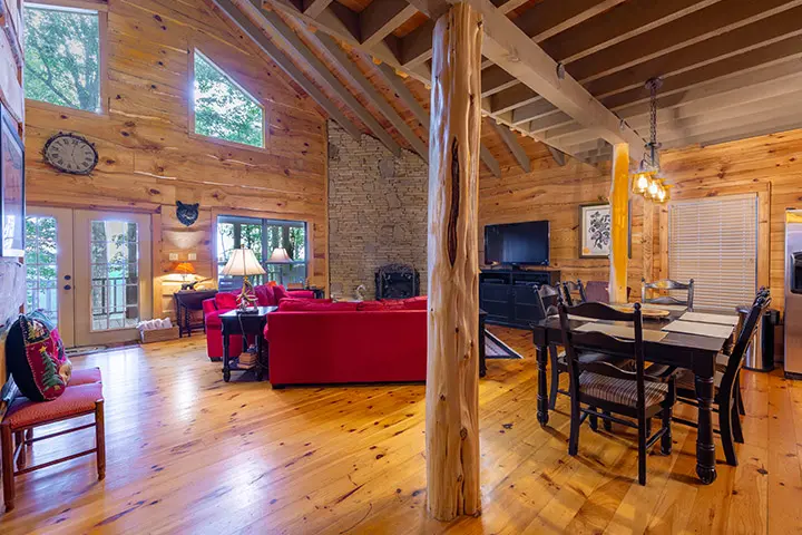 A living room and dining room in a log cabin.