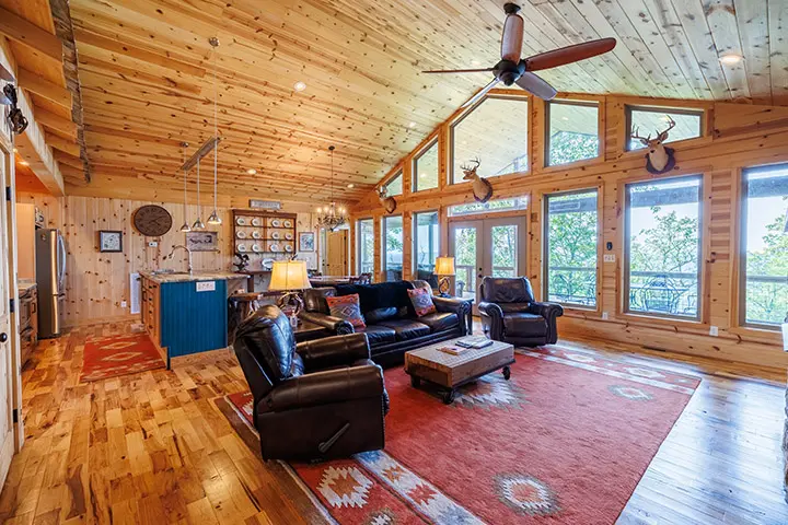 A living room in a log cabin with hardwood floors.