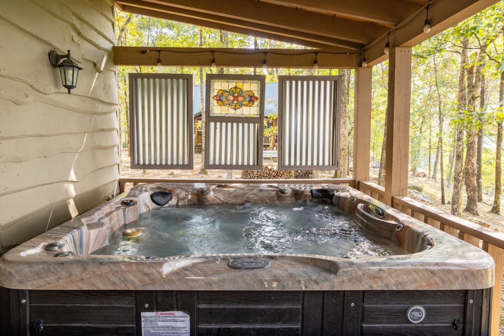 A hot tub on the porch of a cabin.