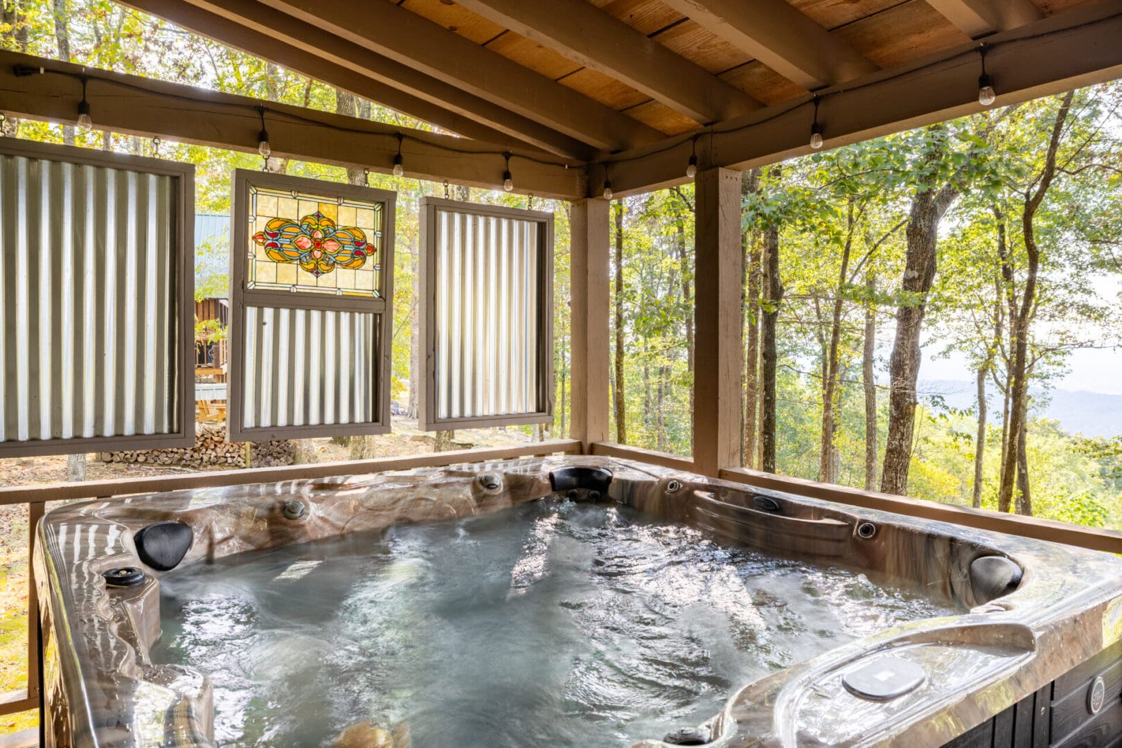 A hot tub on a deck overlooking the woods.