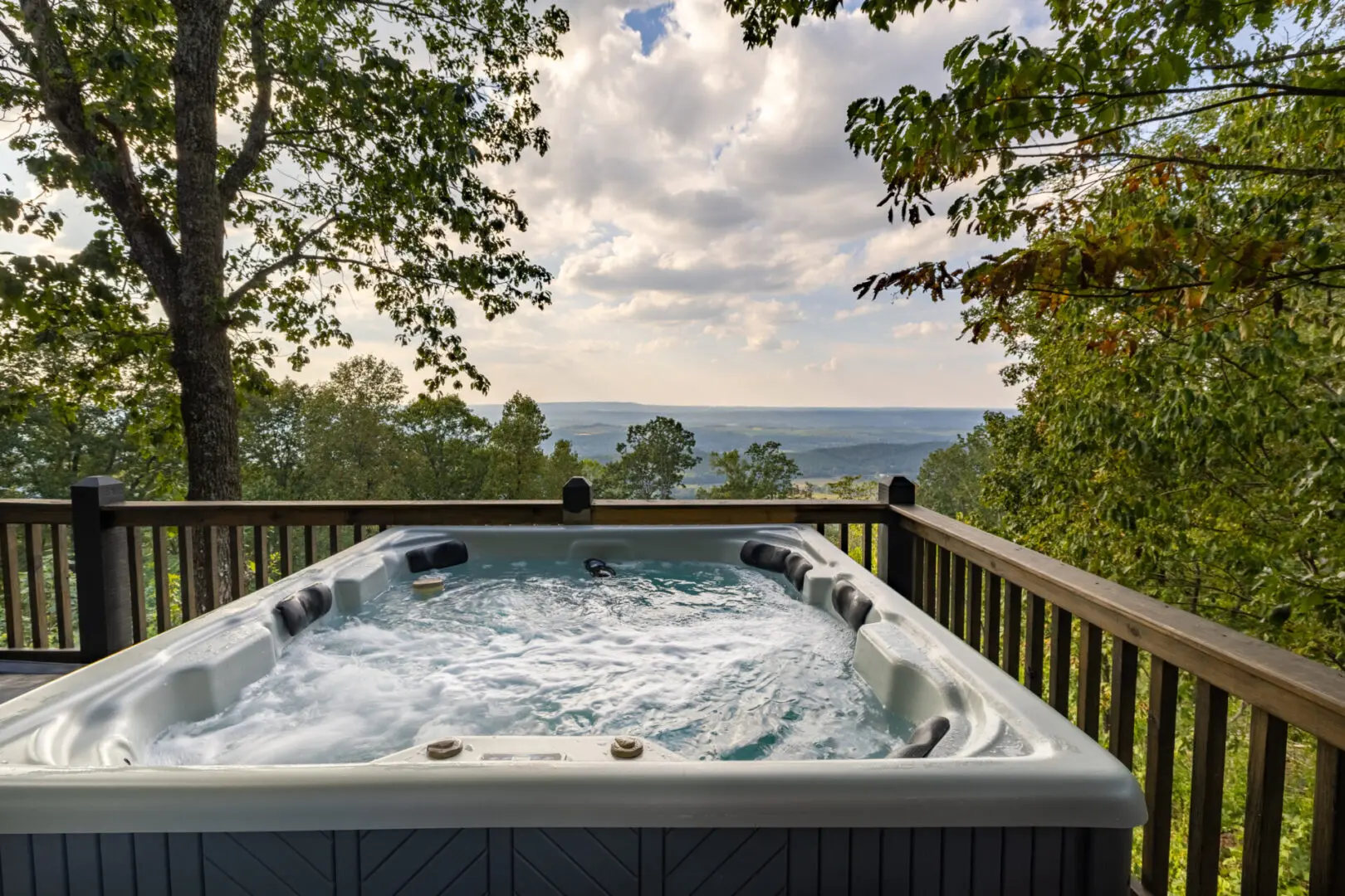 A hot tub on a deck overlooking the mountains.