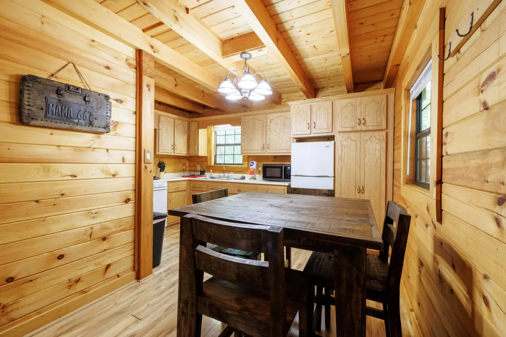 A kitchen in a log cabin with a table and chairs.