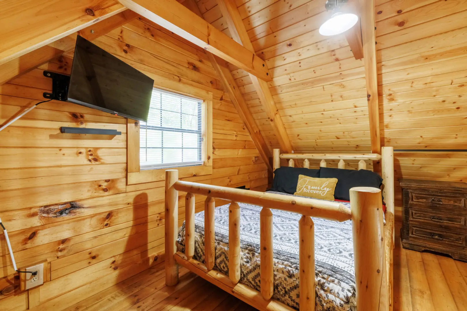A bedroom in a log cabin with a tv.