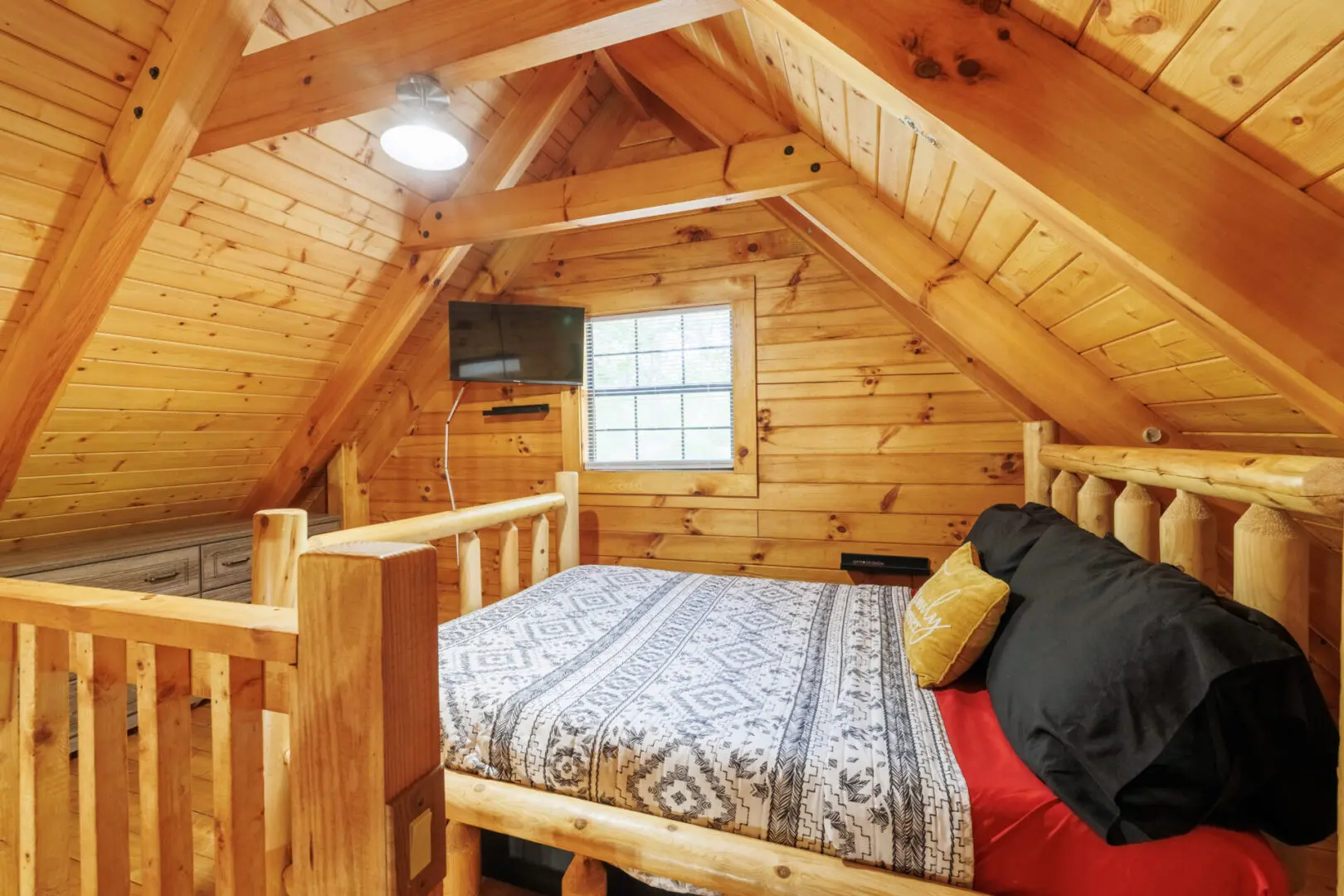 A bedroom in a log cabin with a bed and a tv.