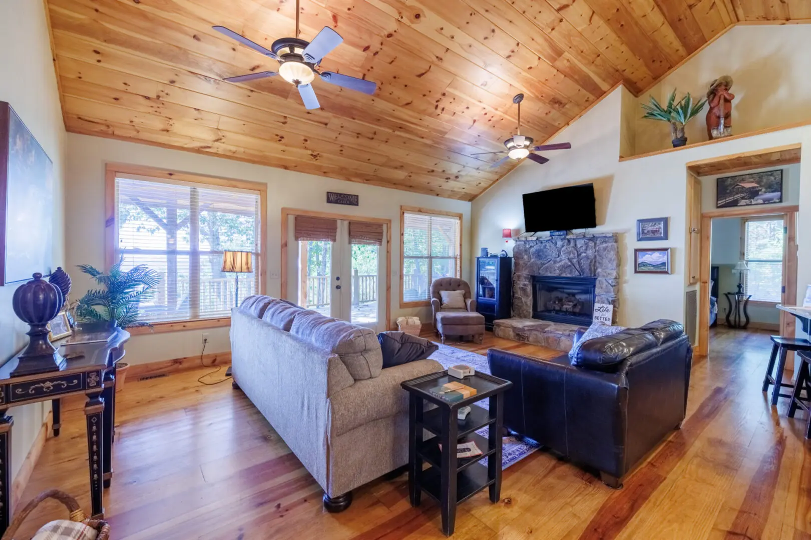 A living room with wood floors and a ceiling fan.