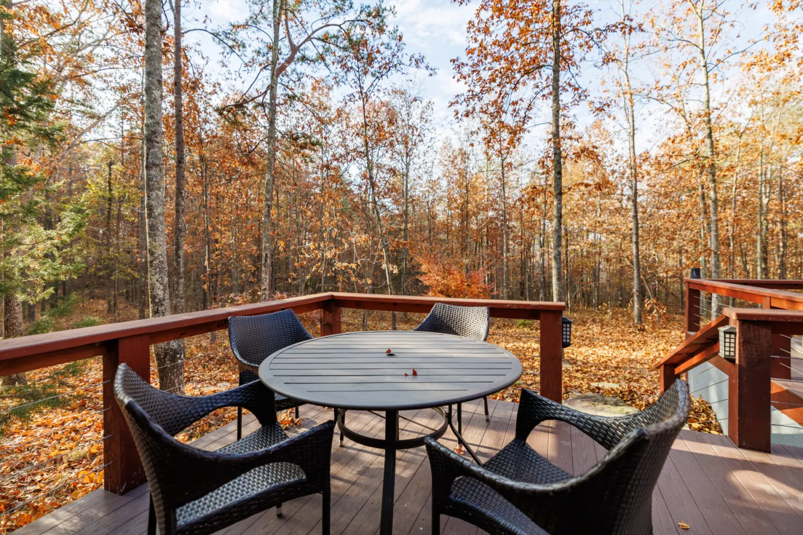 A deck with a table and chairs in the fall at Little River Point.