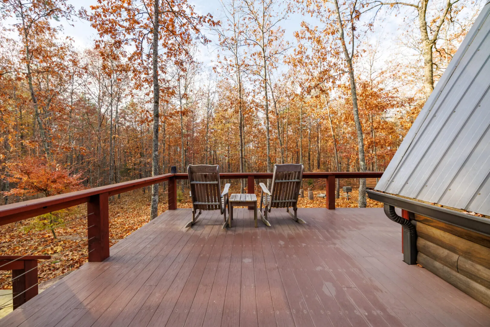 The deck of a Little River cabin in the woods.