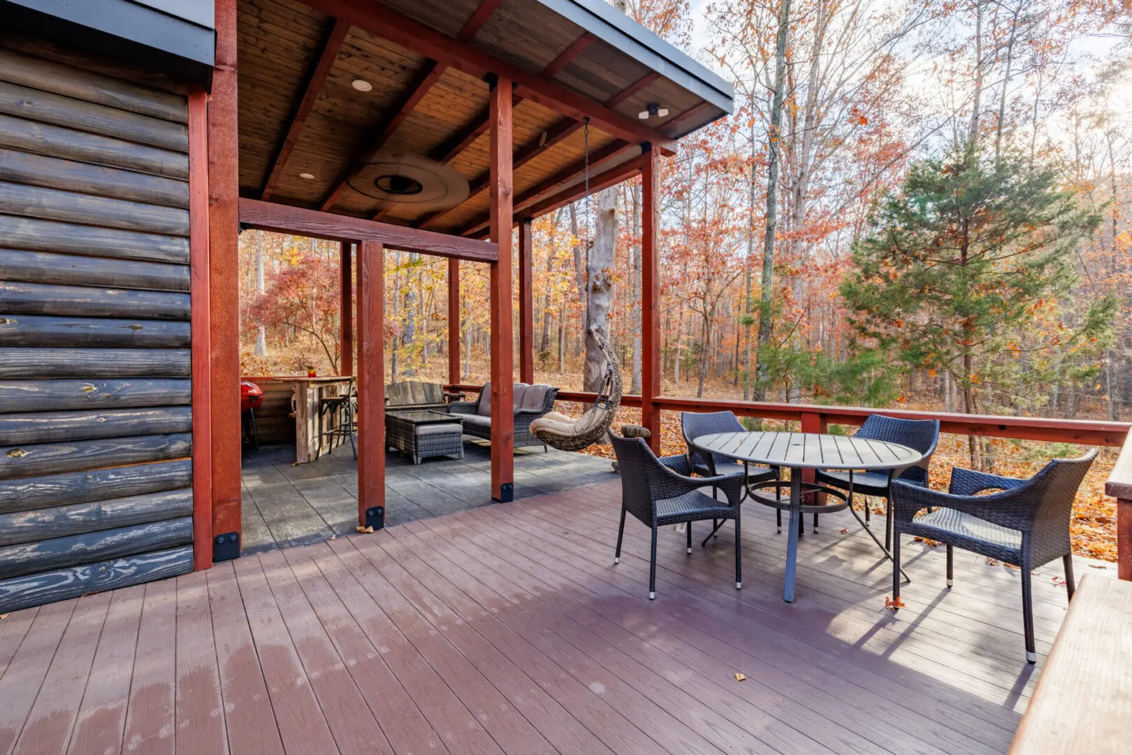 A cozy log cabin nestled in the woods with a deck overlooking the Little River.