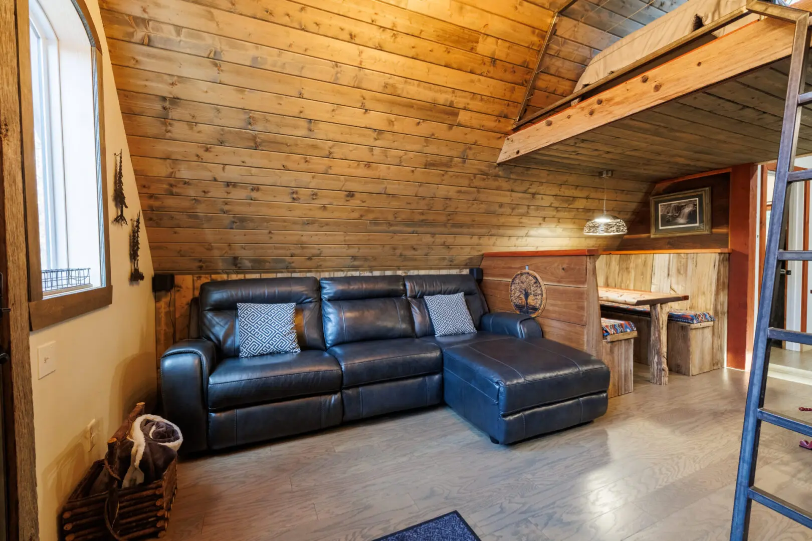 A cozy living room in a tiny house with a ladder.