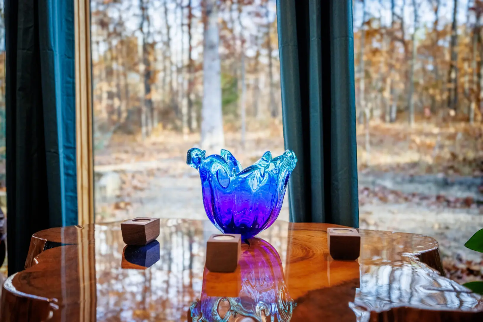 A little blue vase sits on a table in front of a window at Little River Point.