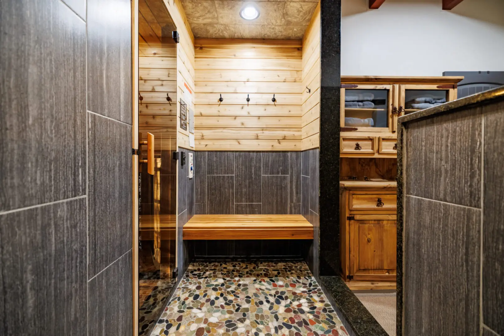 A sauna at Little River Point with a wood bench and a stone floor.