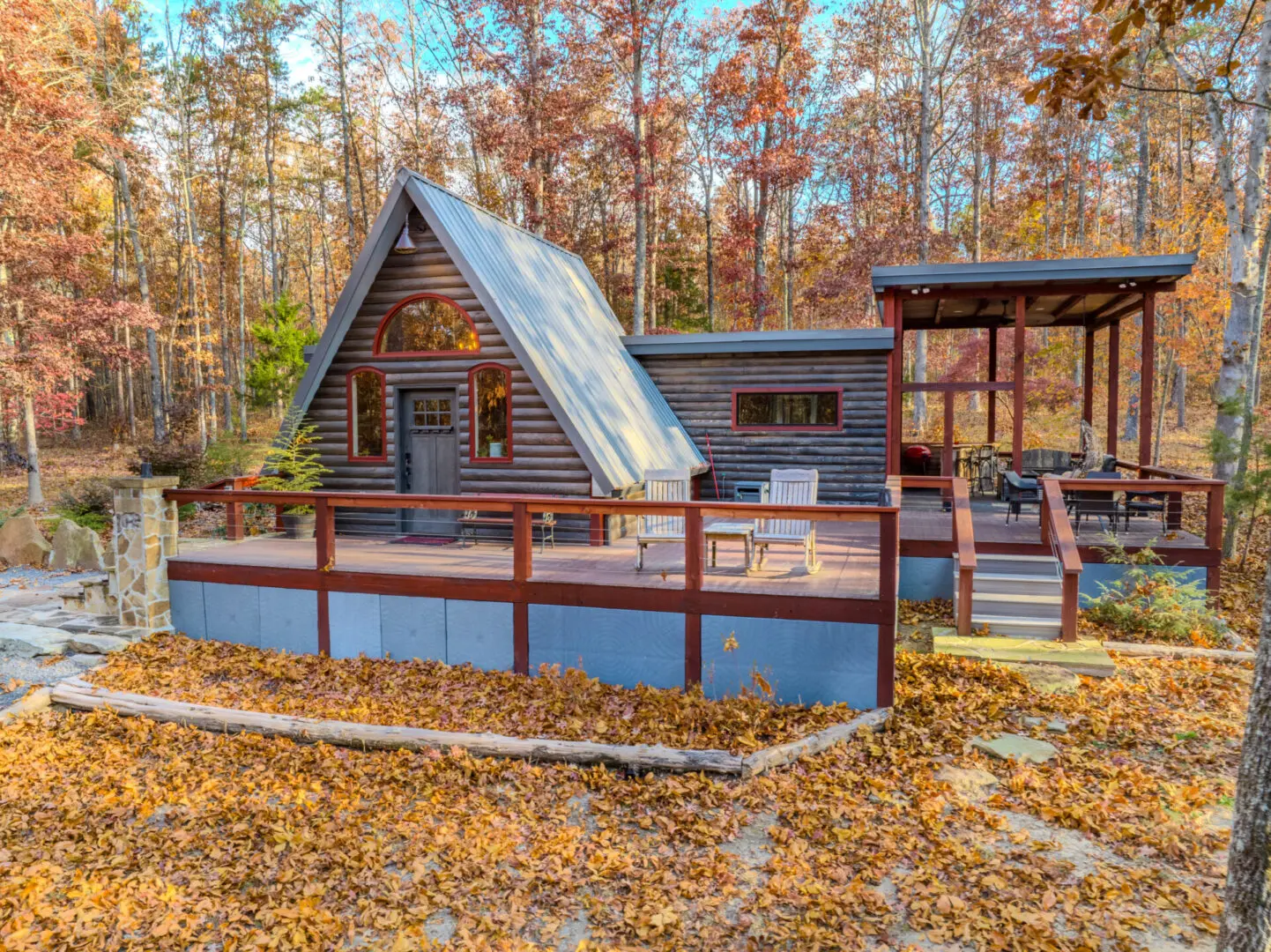 A cabin with a deck and a porch in the woods available for rental in Mentone.