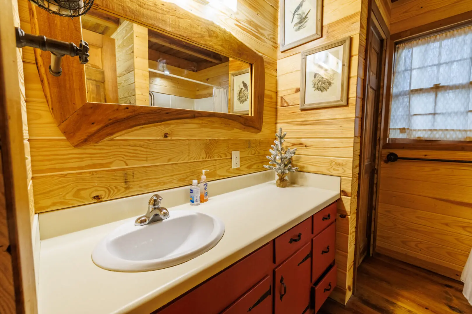 A vacation bathroom in a log cabin with a sink and a mirror.