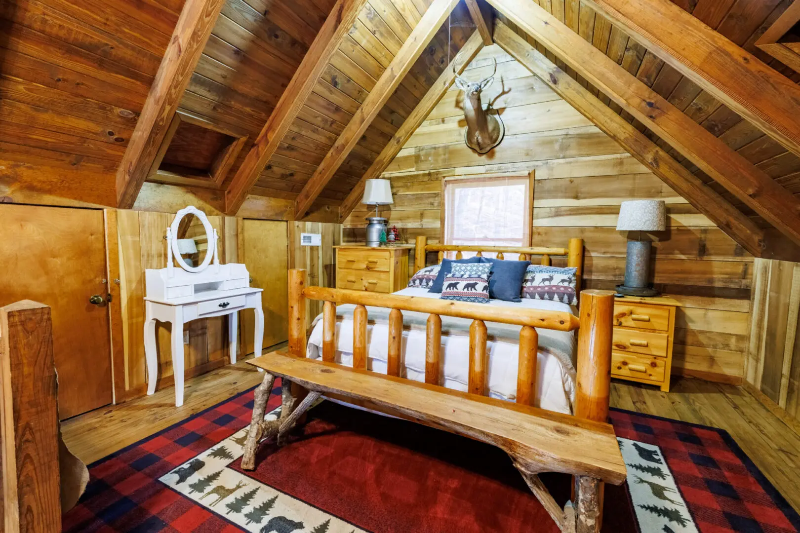 A cozy vacation bedroom in a log cabin, complete with a comfortable bed and a spacious dresser.