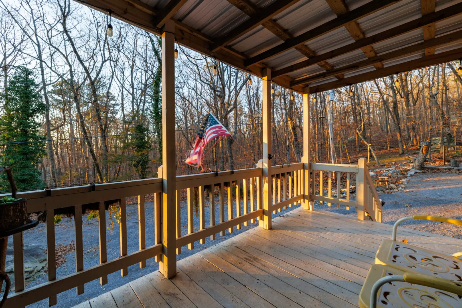 A wooden porch with an american flag, perfect for a relaxing vacation.