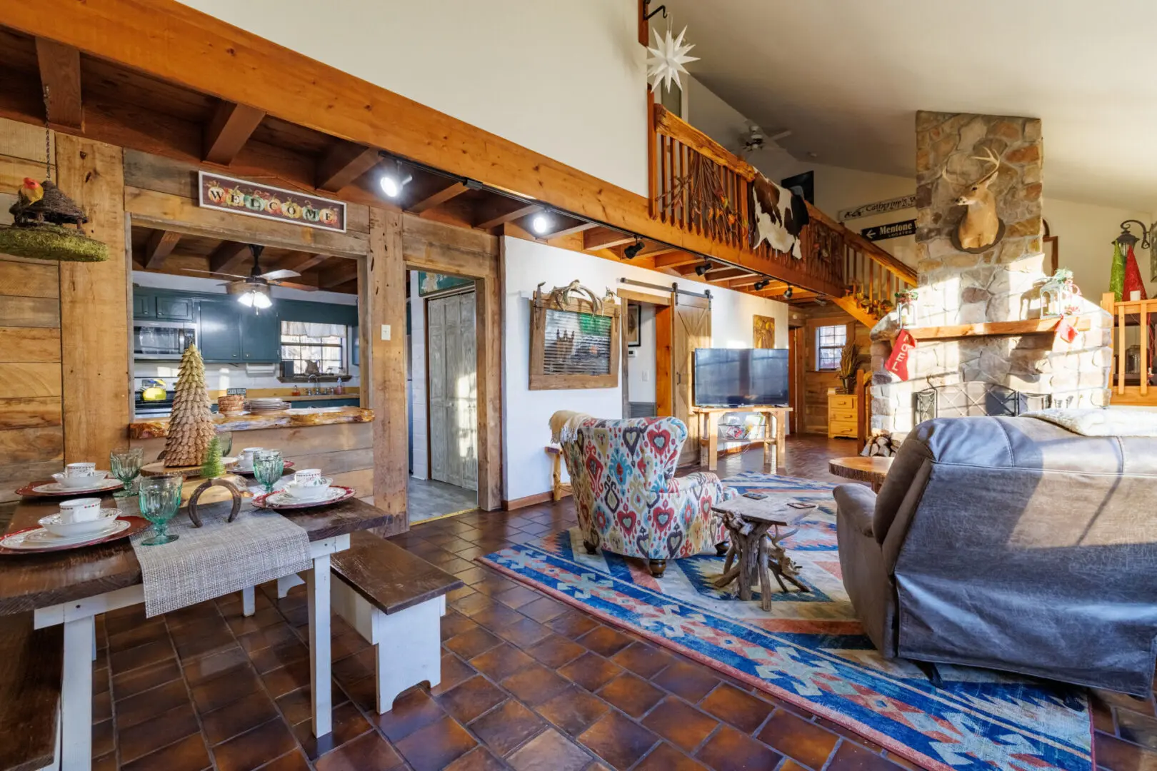 A cozy vacation retreat featuring a living room with a fireplace and beautiful wood beams.