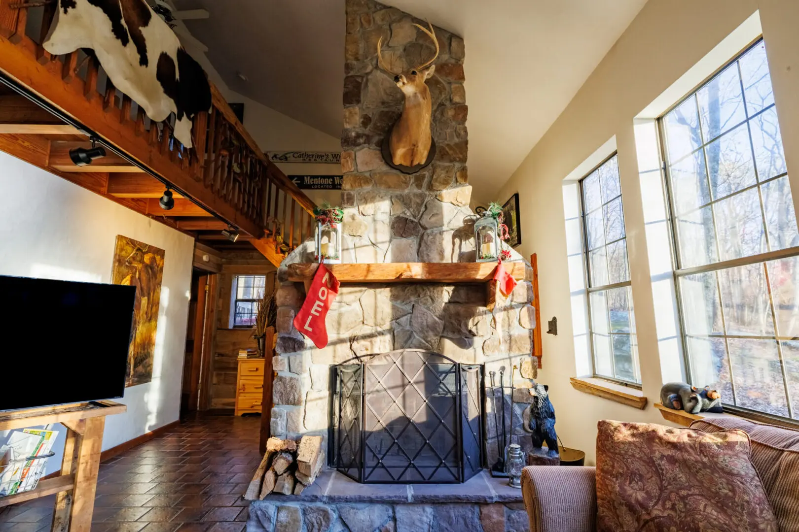 A cozy vacation retreat with a stone fireplace and a warm wood floor.
