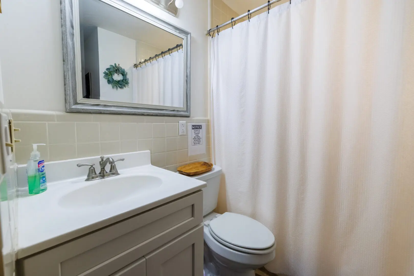 A vacation bathroom with a toilet, sink, and shower curtain.
