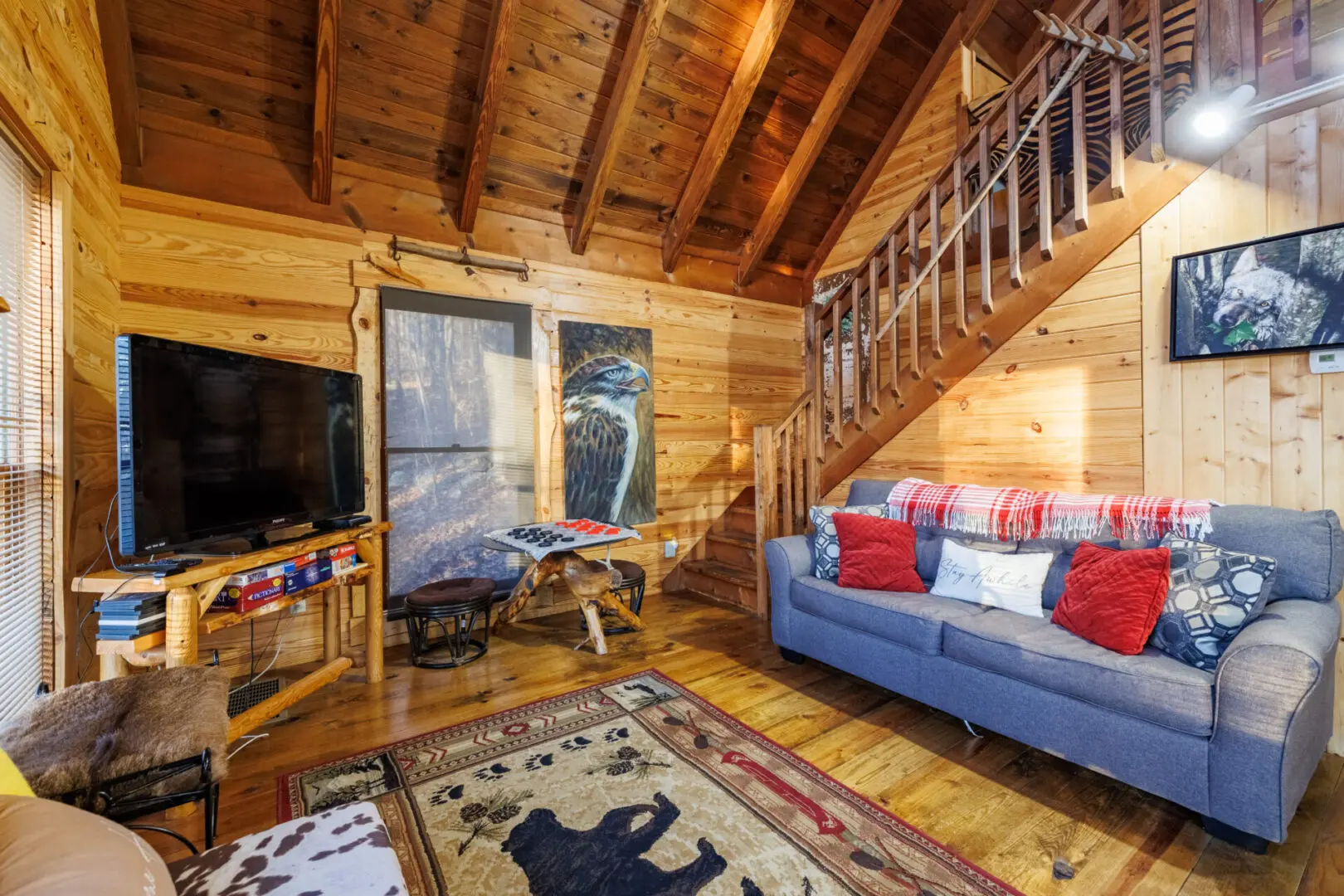 A cozy living room in a log cabin perfect for a relaxing vacation, complete with a tv.