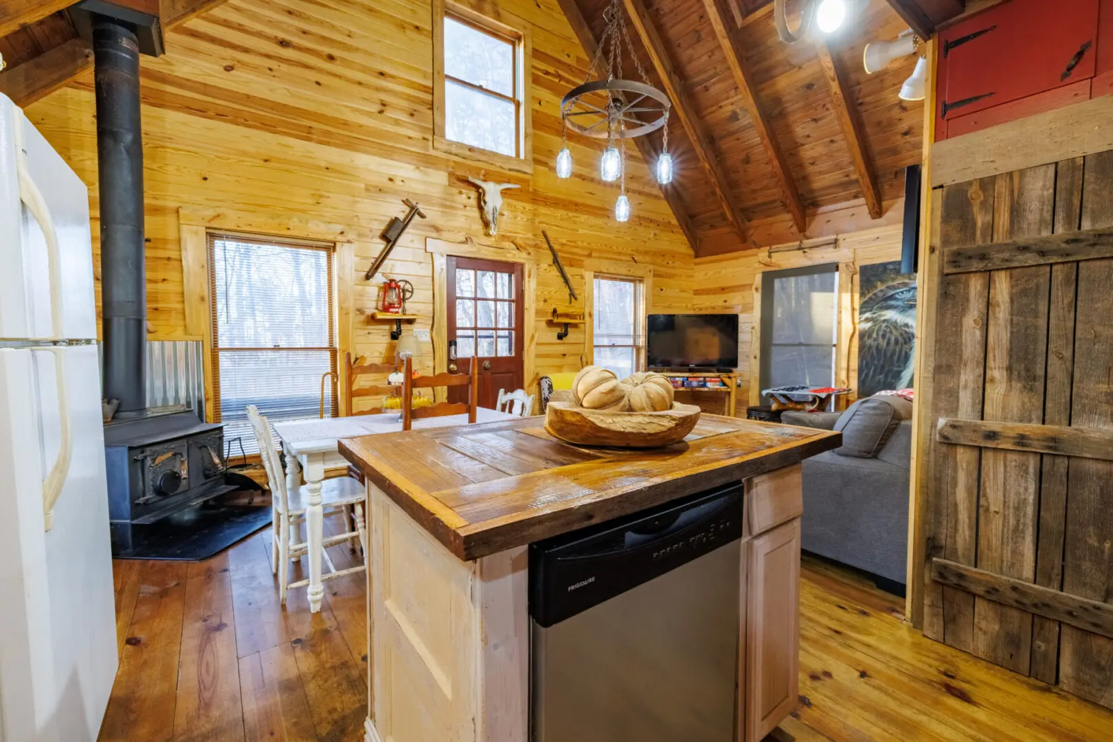 A cozy kitchen in a log cabin with a stove and oven, perfect for a relaxing vacation.