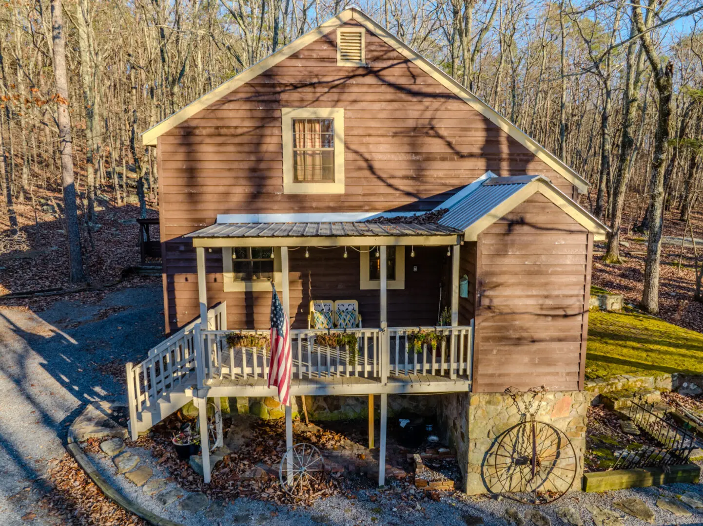 A vacation house with a porch and a wheel on the side.