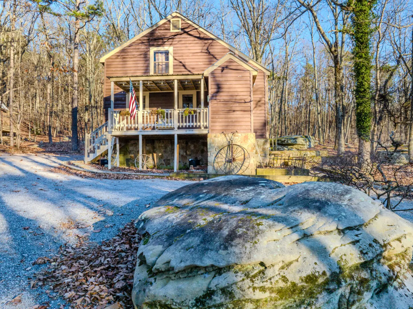 Cabin Rentals in Mentone: A cozy cabin nestled in the tranquil woods with a charming rock in front.