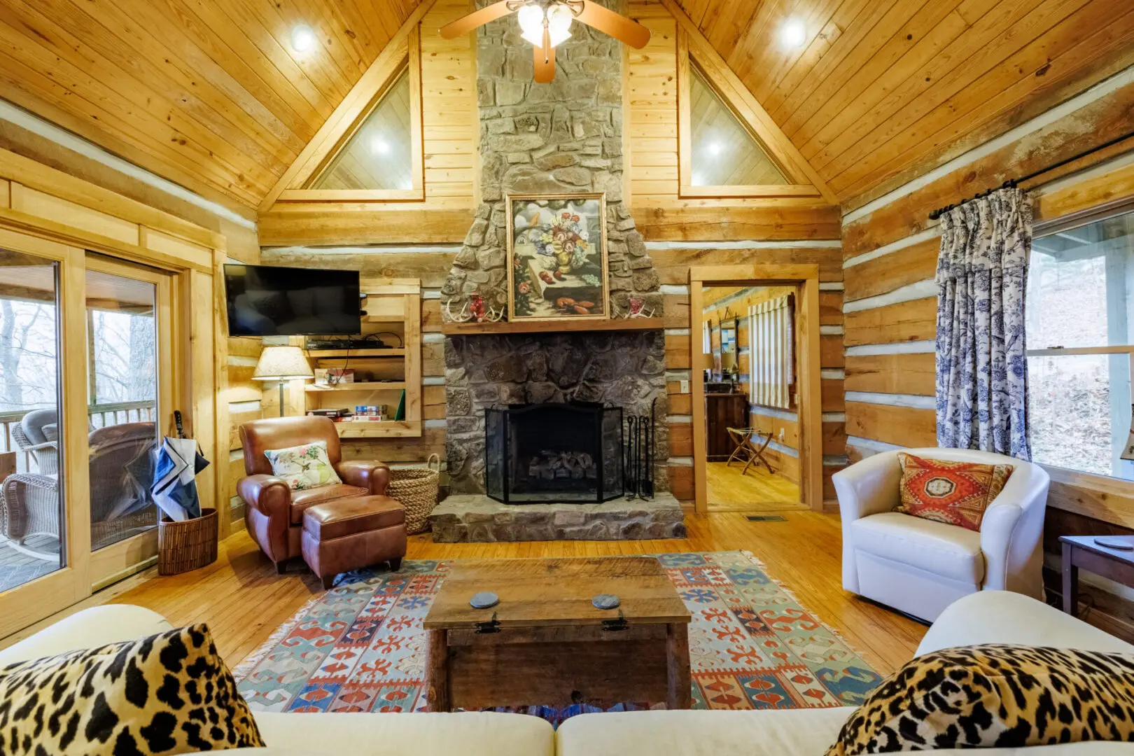A living room in a log cabin with a fireplace.