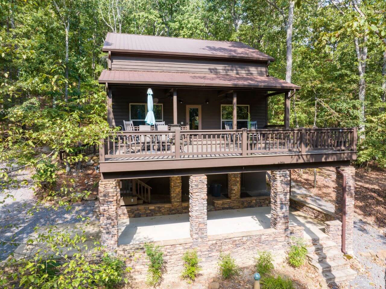 A scenic aerial view of a cozy cabin nestled in the woods of Mentone.